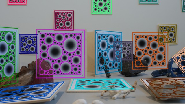 A cluttered scene with many BlobBoards at different distances and angles, each outlined in a distinct colour with its blob pattern re-projected onto the board.